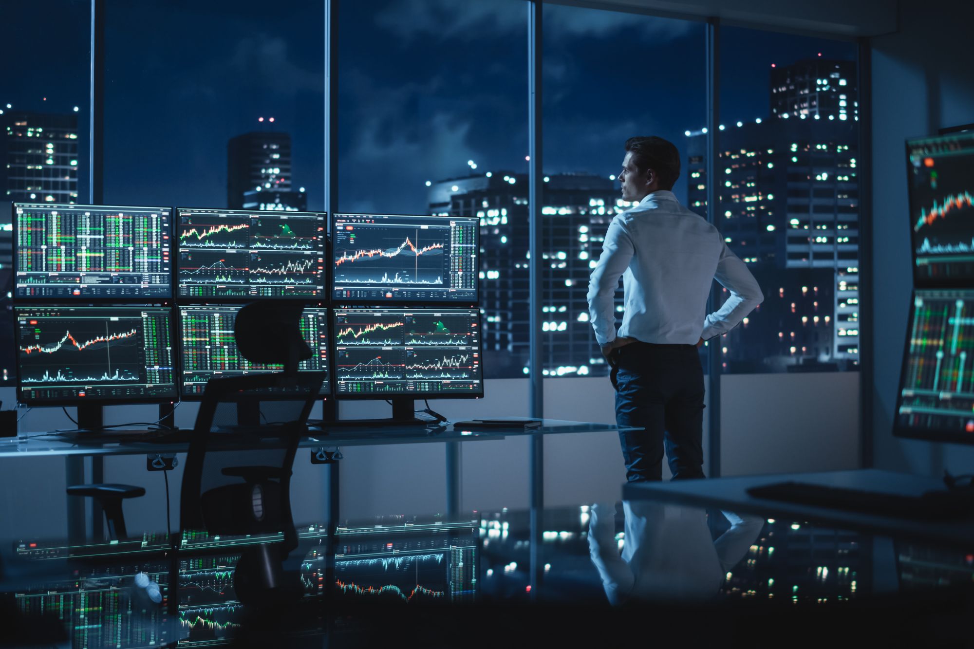 Successful Businessman Looking Out Of The Window On Late Evening.