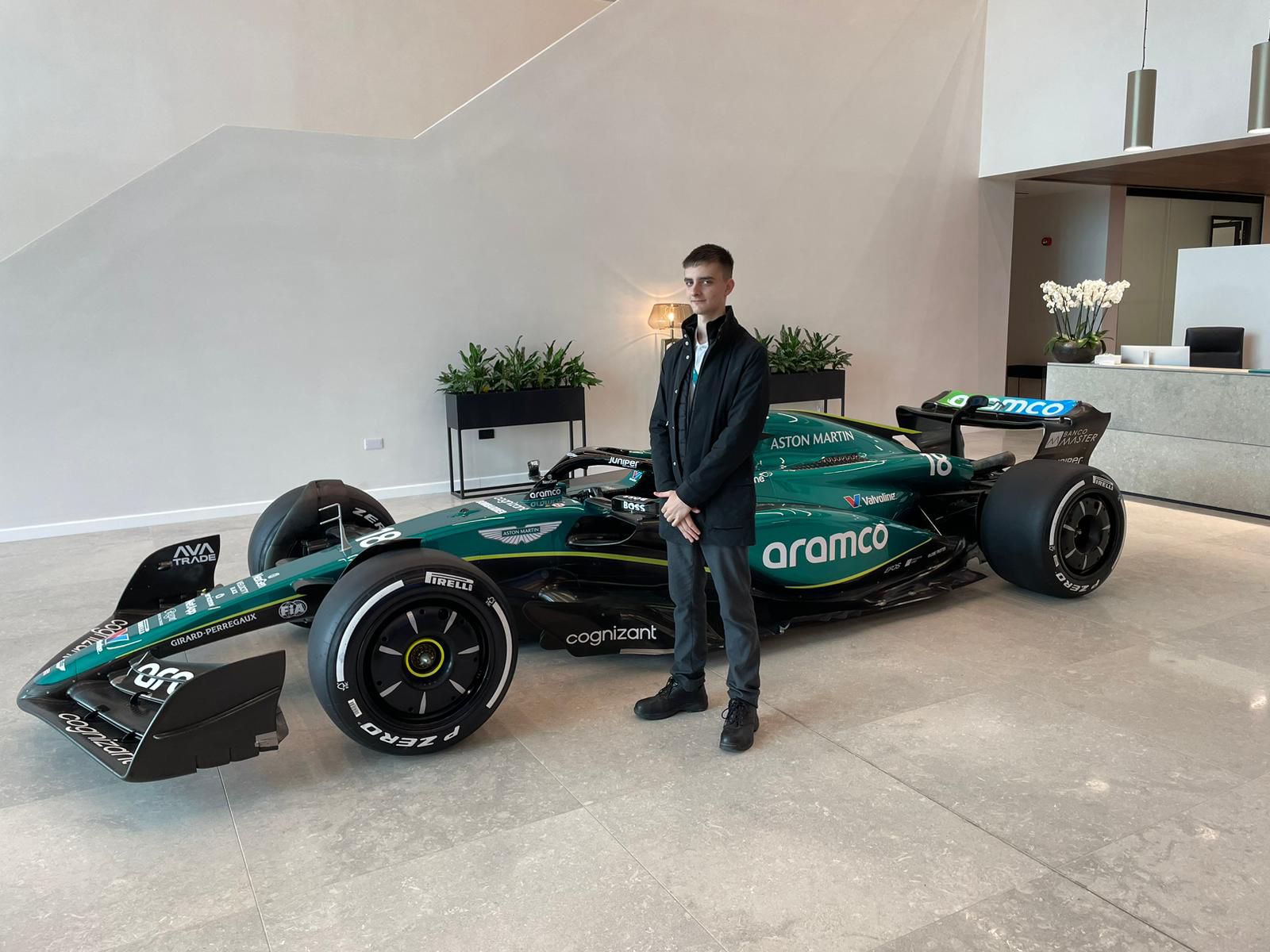 Dan Callaghan proudly stands next to an Aston Martin car at Silverstone